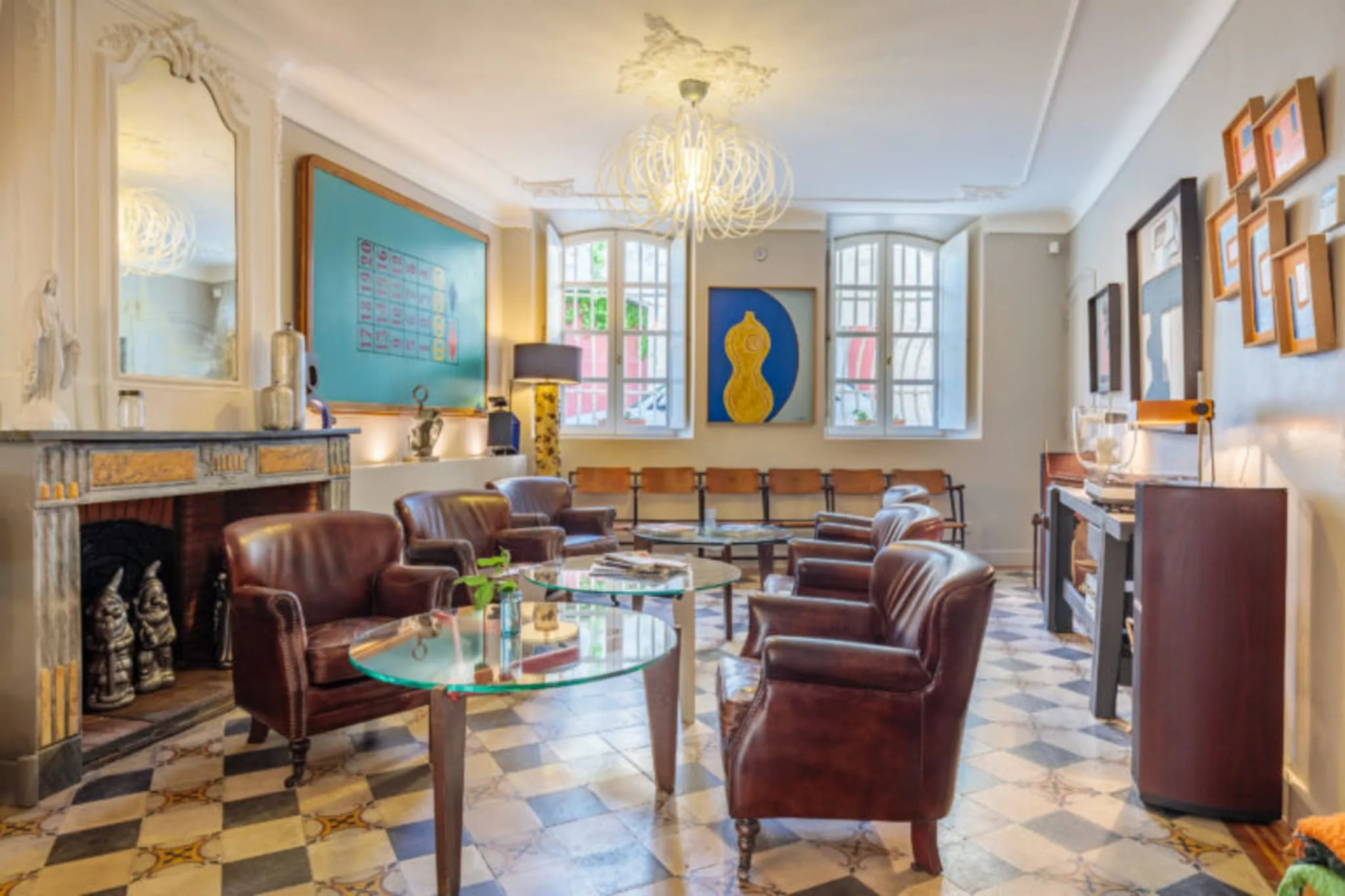 Salon de l’Hôtel La Suite : fauteuils en cuir et cheminée